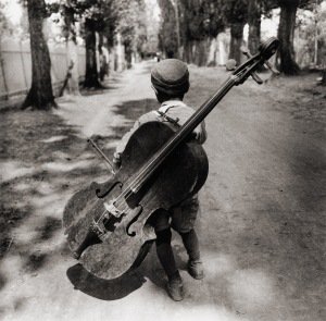 Éva Besnyő: Gypsy boy with cello, Hungary 1931 "Au premier rang venaient les violons, précédant les violoncelles suspendus aux épaules par des moyens de fortune."